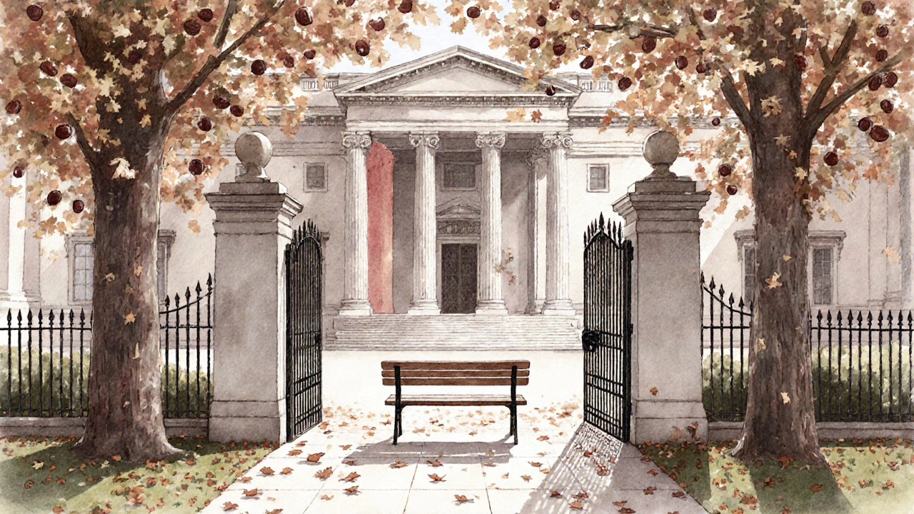 The original 1817 iron gates of Dulwich Picture Gallery surrounded by falling leaves in a quiet garden.